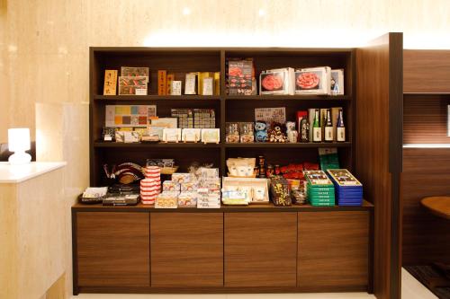 a book shelf with food and other items on it at Hotel Sunroute Hikone in Hikone