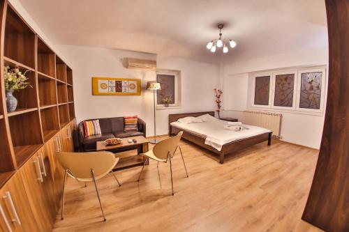 a bedroom with a bed and a table and chairs at Dream Residence splai in Bucharest