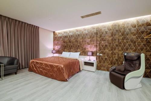 a hotel room with a bed and a chair at 富士都商務汽車會館 台南市旅館308號 in Tainan