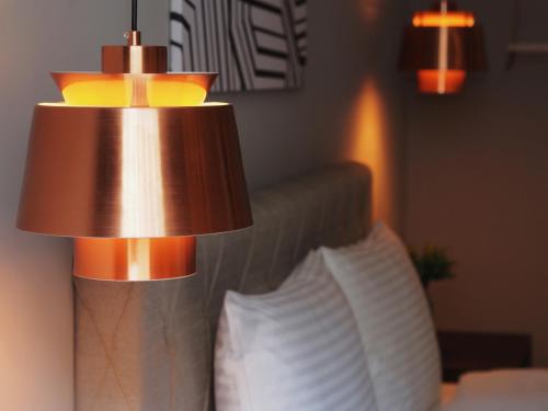 a lamp on the side of a bed with two pillows at Anson 19 B&B in Lugang