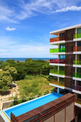 an apartment building with a swimming pool and the ocean at Rocco Hua Hin Beach Seaview in Hua Hin