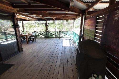 a wooden deck with a table and chairs on it at Silverpoint Estate in Pokolbin