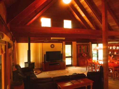a living room with a couch and a flat screen tv at Silverpoint Estate in Pokolbin