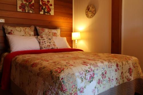 a bedroom with a bed with a floral bedspread at Silverpoint Estate in Pokolbin