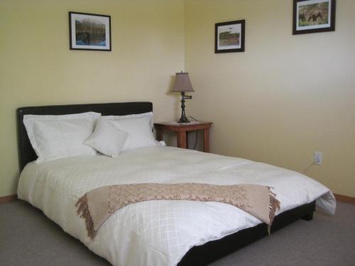 a bedroom with a large bed with white sheets and pillows at Wild Nature B&B in Kelowna