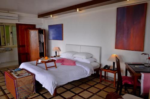 a bedroom with a bed and a table and a desk at Punta Bulata White Beach Resort & Spa in Sipalay