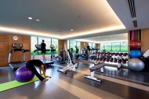 a gym with a woman doing exercises on a fitness ball at Amari Hua Hin in Hua Hin