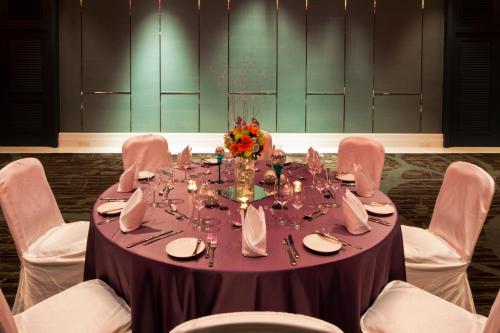 a table with white chairs and a purple table cloth at Amari Hua Hin in Hua Hin