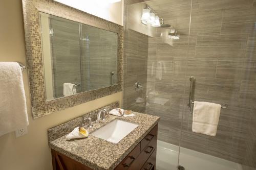 a bathroom with a sink and a shower with a mirror at Banff Boutique Inn - Adults only in Banff
