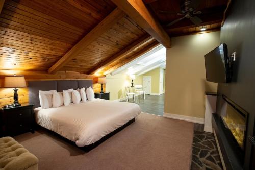 a bedroom with a large white bed and a tv at Banff Boutique Inn - Adults only in Banff