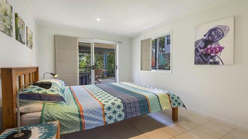 a bedroom with a bed and a window at Moana Retreat in Lennox Head