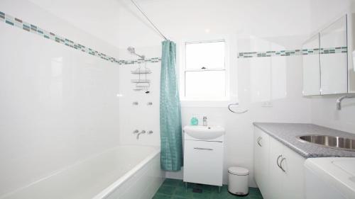 a white bathroom with a tub and a sink at My Blue Heaven - Dog Friendly in Lennox Head