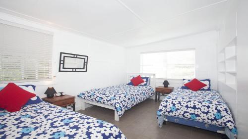 a bedroom with two beds with blue and red pillows at My Blue Heaven - Dog Friendly in Lennox Head