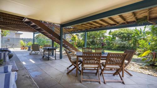 a patio with a table and chairs and a staircase at Moana Retreat in Lennox Head