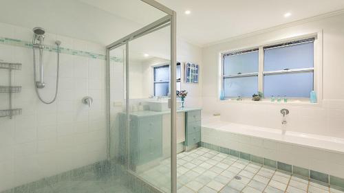 a bathroom with a shower and a tub and a sink at Moana Retreat in Lennox Head