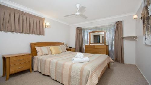 - une chambre avec un lit et une serviette blanche dans l'établissement Alexander Palms, à East Ballina