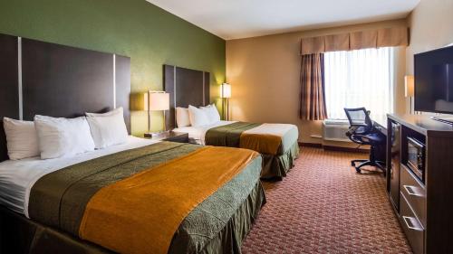 um quarto de hotel com duas camas e uma televisão em Best Western Plus North Houston Inn & Suites em Houston
