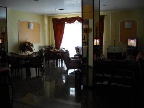 d'un salon avec une table, des chaises et une fenêtre. dans l'établissement Hotel La Corte, à Rubiera
