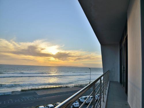 a balcony of a building with a view of the ocean at Blaauwberg Beach Hotel in Bloubergstrand