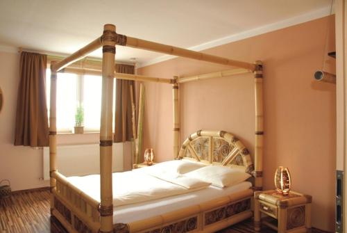 a canopy bed in a bedroom with a window at Hotel Rosenhof in Isenbüttel