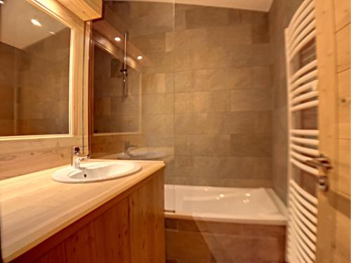 uma casa de banho com um lavatório e uma banheira em La Durance em Montgenèvre