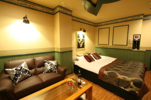 a bedroom with a bed and a couch at Restay Kokura (Adult Only) in Kitakyushu