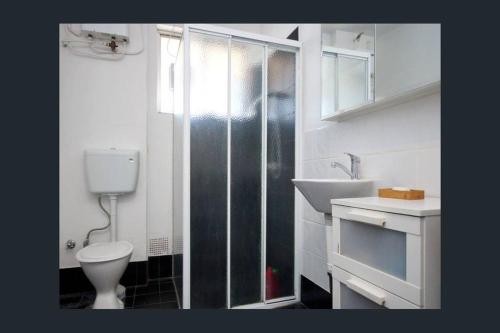 uma casa de banho com um chuveiro, um WC e um lavatório. em Affordable Apartment close to city and Beaches em Perth