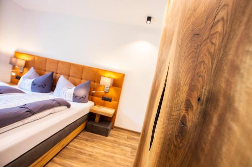 a bedroom with a bed with a wooden headboard at Biwak Appartements in Sankt Anton am Arlberg
