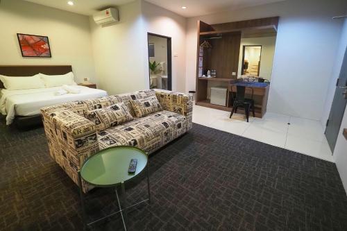 a hotel room with a couch and a bed at S Boutique Hotel in Ipoh