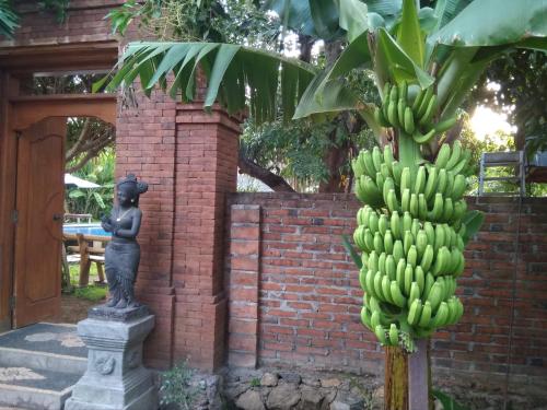 a statue of a girl next to a bunch of bananas at Suka Sari Cottages in Pemuteran