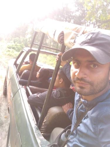 a man sitting in the back of a truck at Chital lodge in Chitwan