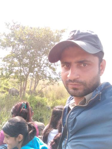 a man wearing a hat standing in front of a group of people at Chital lodge in Chitwan