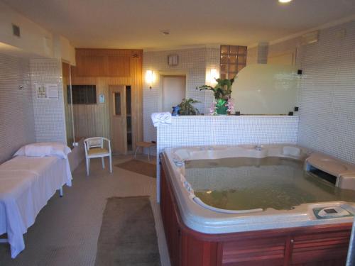 a bathroom with a large tub filled with water at Hotel San Francisco Spiaggia in Rimini