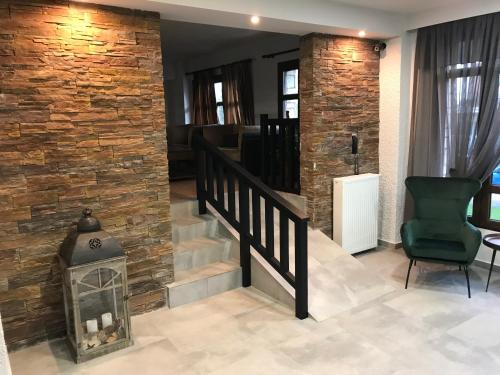 a living room with a brick wall and a fireplace at Filoxenia Hotel & Spa in Kalavrita