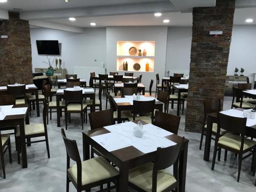 um restaurante com mesas e cadeiras num quarto em Filoxenia Hotel & Spa em Kalavrita