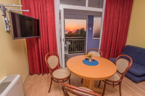 a living room with a table and chairs and a television at Aparthotel Pecic in Gradac