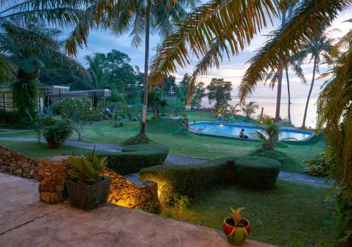 a resort yard with a swimming pool and palm trees at Elephant Bay Resort in Ko Chang
