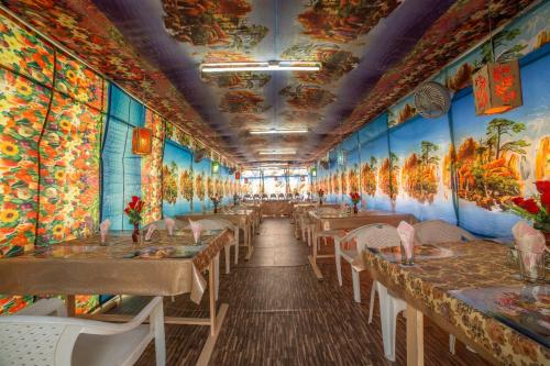 a dining room with paintings on the walls at Swan Group of Houseboats, Golden Dal Lake in Srinagar