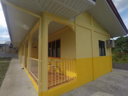 a yellow building with a gate on the side at Uptown Guesthouse in Siquijor