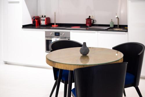 a kitchen with a table and chairs and a counter at La Casa del Consul in Cádiz