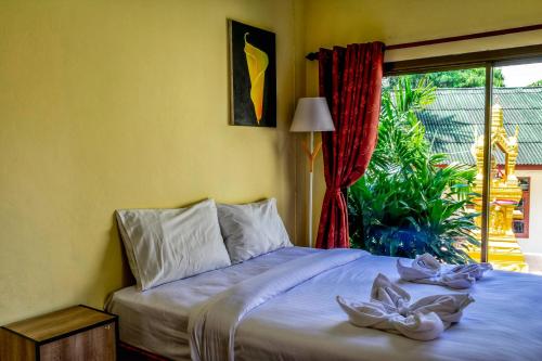 a bedroom with a bed with two shoes on it at Kata Leaf Resort Phuket - SHA Extra Plus in Kata Beach