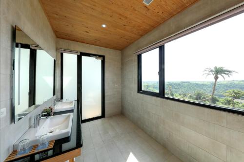 a bathroom with two sinks and large windows at SkyeBay Club in Hengchun