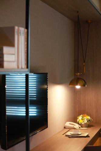 a kitchen with a wooden table with a phone and flowers at Queena Plaza Hotel in Yongkang