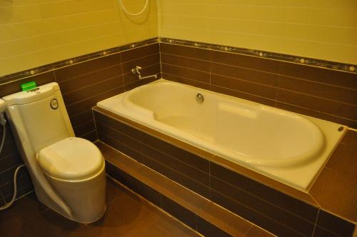 a bathroom with a toilet and a bath tub at Phu Qui Hotel in Soc Trang