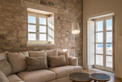 a living room with a couch and two windows at BASSA MAINA Villas & Suites in Areopolis