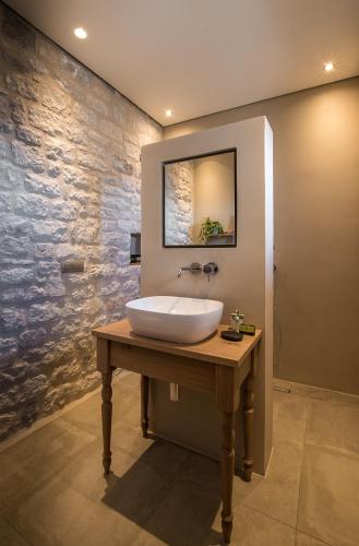 a bathroom with a white sink on a wooden table at BASSA MAINA Villas & Suites in Areopolis
