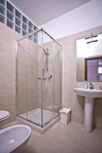 a bathroom with a glass shower and a sink at La Maison di Brigitte e Simone in Bentivoglio