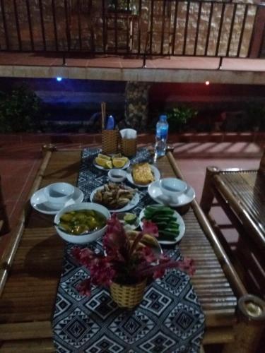 a table with plates of food on a table at Mai Chau Xanh Bungalow in Mai Chau