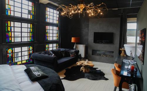 a living room with a couch and a chandelier at Hotel Huis van Bewaring - Bijzonder boutique hotel in historisch pand in Almelo