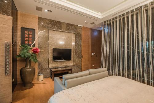 a living room with a couch and a tv in a room at Motel Stars in Taichung